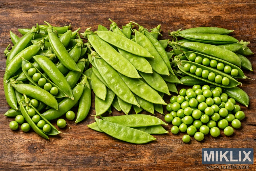 高解析度照片顯示，甜豌豆、雪豌豆和剝殼豌豆並排擺放在質樸的木質表面上。