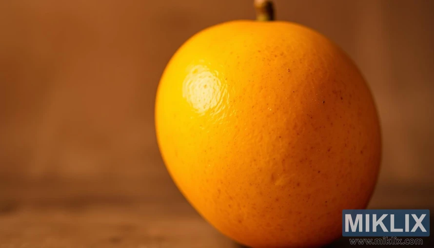 A vibrant, close-up portrait of a ripe mango, its luscious golden skin glowing under a soft, diffused light. The fruit's surface is dotted with delicate freckles, hinting at its juicy, fragrant flesh within. The mango is positioned against a blurred, ethereal background, allowing the viewer to focus on its captivating details. Warm, earthy tones predominate, creating a sense of natural beauty and nourishment. The overall composition conveys the mango's inherent ability to nourish and rejuvenate the skin.