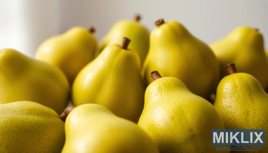 A close-up shot of several ripe, juicy guava fruits against a soft, blurred background. The guavas are displayed in the foreground, showcasing their vibrant green skin with hints of pink blush, and their distinctive teardrop shape. The lighting is soft and natural, creating a warm, inviting atmosphere. The fruits are arranged in a visually appealing manner, highlighting their unique texture and the subtle shadows that accentuate their contours. In the middle ground, there are a few additional guava fruits, slightly out of focus, providing a sense of depth and abundance. The background is hazy and muted, allowing the viewer's attention to be drawn to the vibrant, succulent guava fruits in the center of the frame.