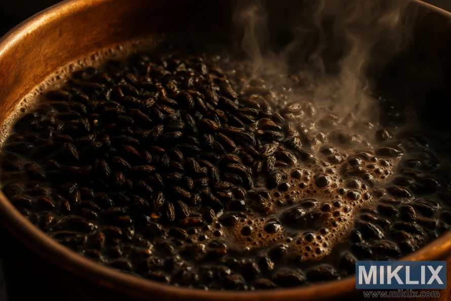 A close-up view of dark, roasted malt grains bubbling and steaming in a copper brew kettle. The grains have a sharp, almost acrid aroma, with hints of burnt toast and bitterness. The kettle is illuminated by a warm, amber glow, casting dramatic shadows and highlights across the roiling surface. The scene is captured with a shallow depth of field, emphasizing the tactile, textural quality of the malts. The overall mood is one of intensity and focus, hinting at the complex flavors and aromas that will emerge from this crucial stage of the brewing process.